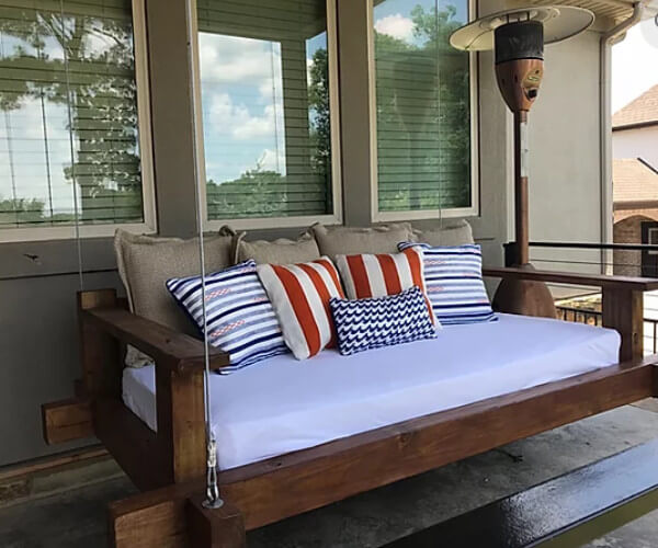 Wood hanging daybed with striped pillows
